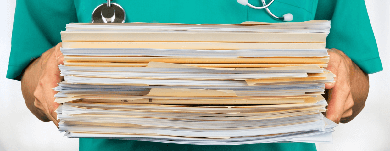 Healthcare worker holding stack of documents