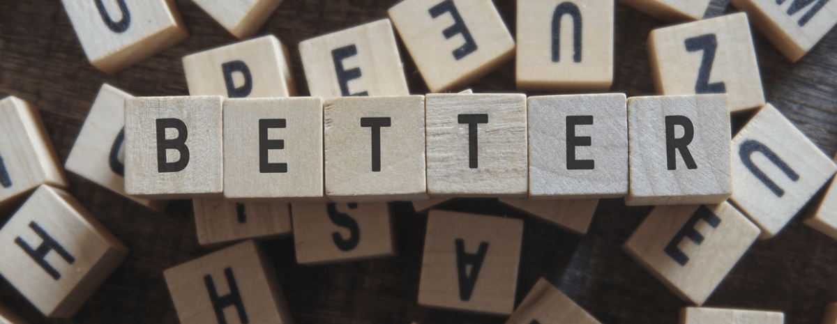 The word better spelled out in wooden blocks on top of jumbled wooden blocks