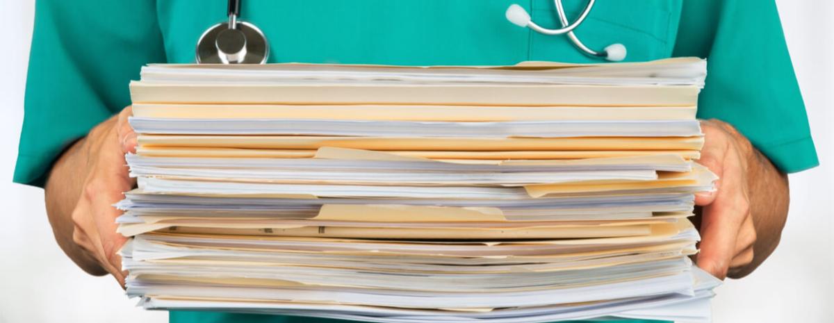 Healthcare worker holding stack of documents